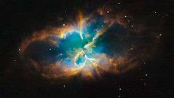 A coloured oval cloud of material against a dark background