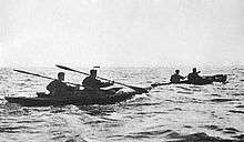 two two man canoes at sea moving from left to right