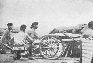 Three artillery men crouch behind a small 2.5 inch "Screw Gun" employed in the defence of Kimberley