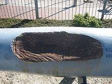 The gray gun barrel has a large gouge in the center where a British shell had struck it.