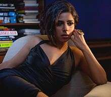 Portrait picture of Sugandha Garg at Aarakshan movie media preview. Her brunette hair is loose over her shoulders and she is wearing black rimmed 'Clark Kent' style glasses.