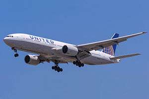 Aircraft landing approach. Front quarter view of twin-engine jet in flight with flaps and landing gear extended.